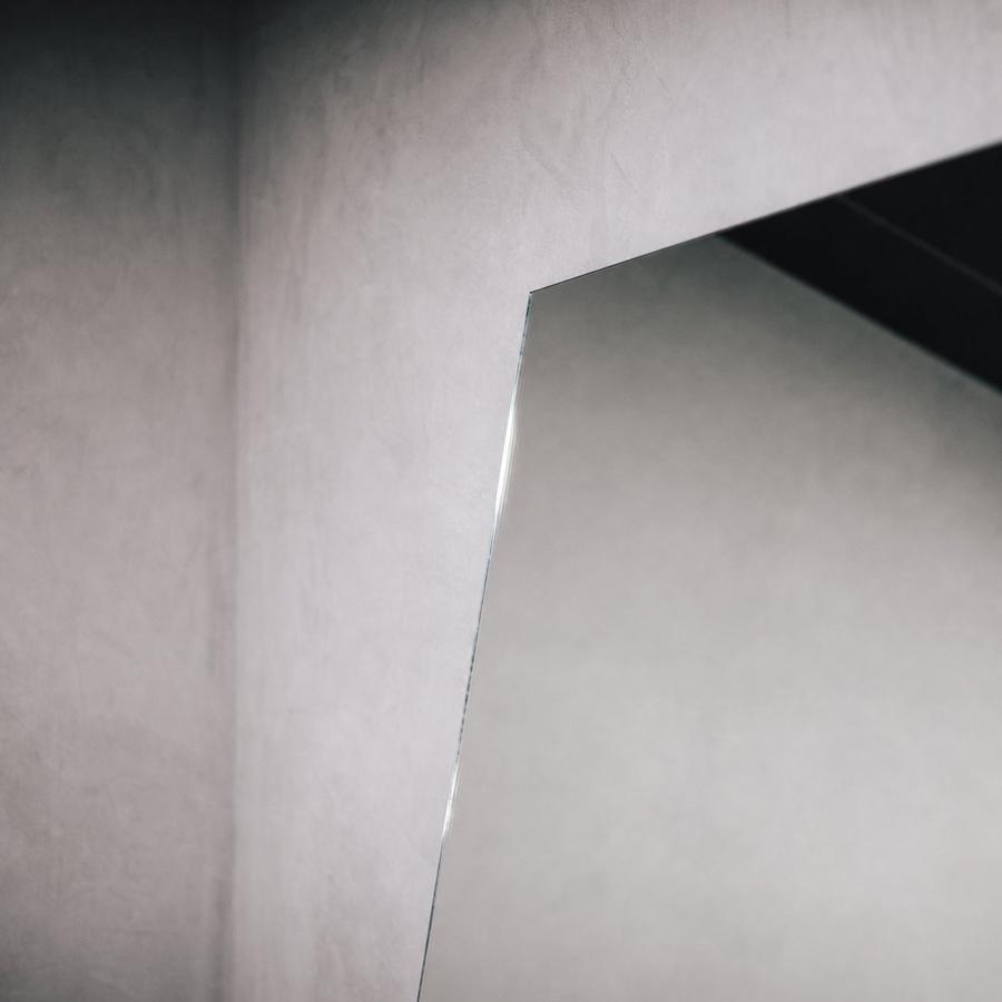 Minimalist concrete wall and leaning mirror detail inside IKIGAI Studio